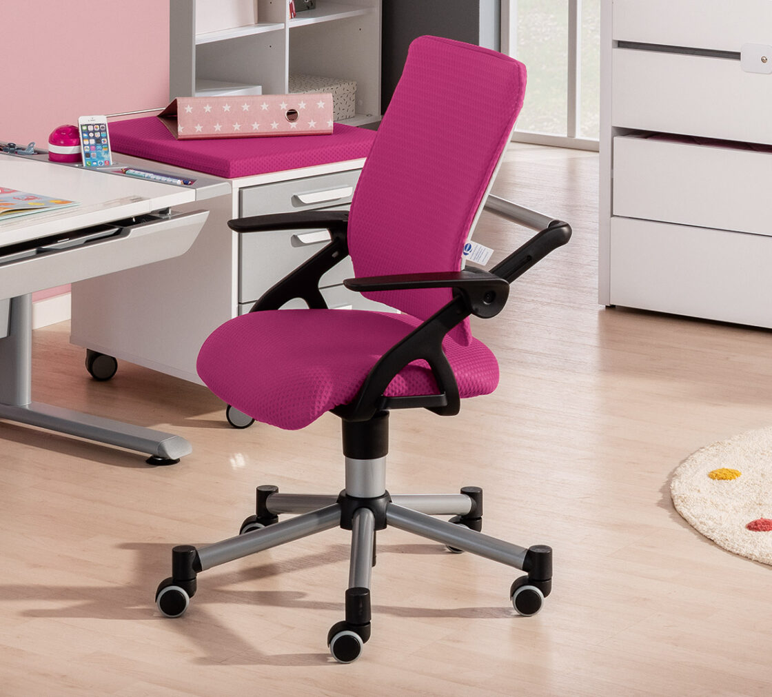 PAIDI Schreibtischstuhl Tio mit pinker Polsterung, schwarzen Armlehnen und grauem Drehfuß auf Rollen in einem modernen Kinderzimmer.